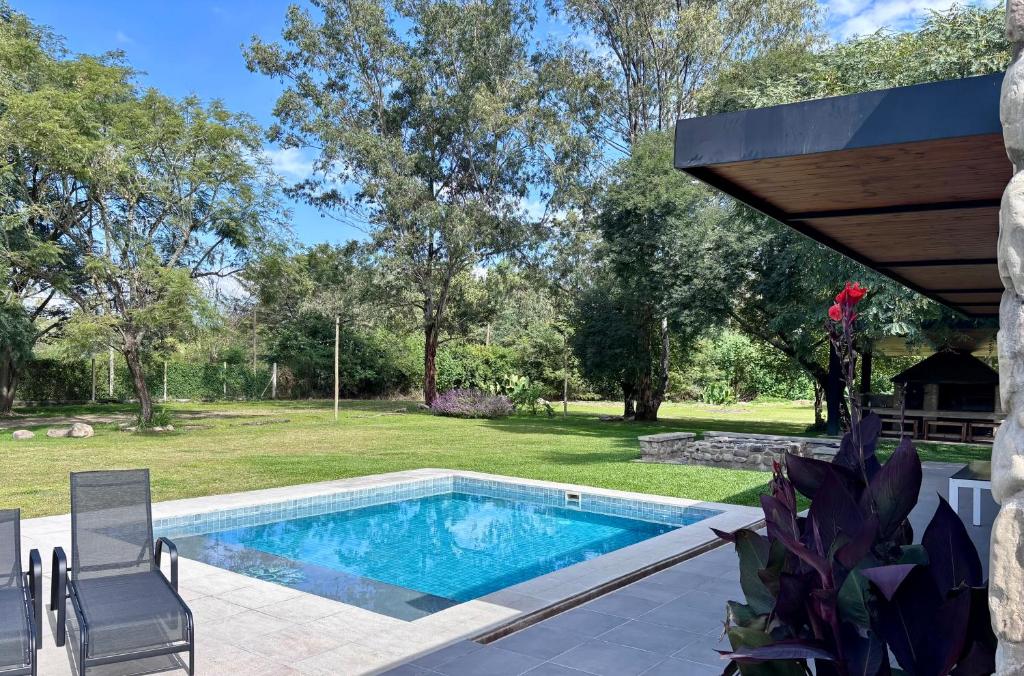 a swimming pool in a yard with a table and chairs at Loto San Lorenzo Studio I balcón, vista cerros y piscina in San Lorenzo