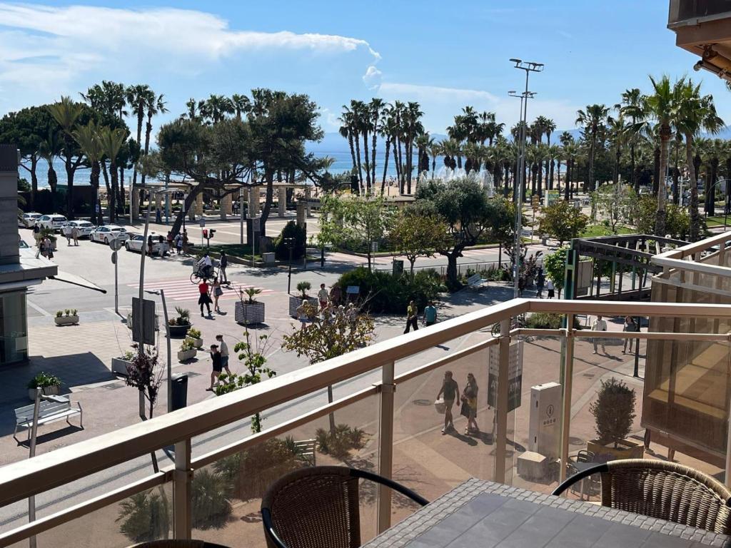 a balcony with a view of a park with palm trees at El Pinar Fuente Luminosa in Salou