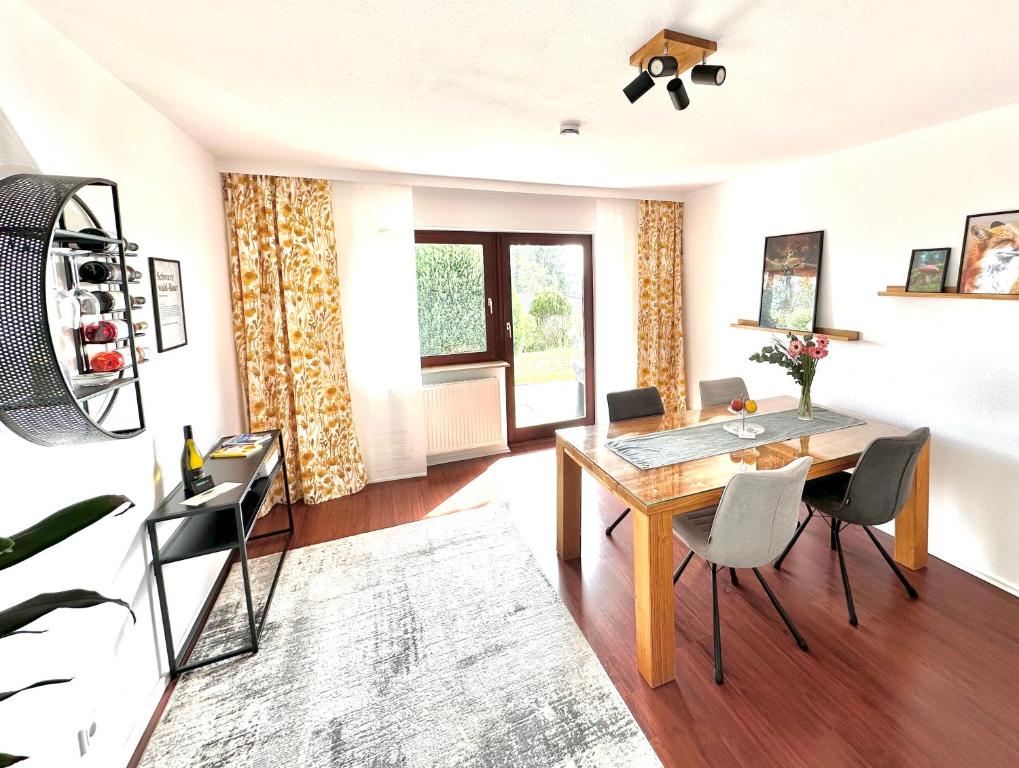 a living room with a dining room table and chairs at Apartment Kneer - Panoramic View & Private Garden near Black Forest & Lake Constance in Donaueschingen