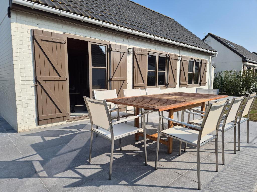 a wooden table and chairs in front of a building at Port Griad in De Haan