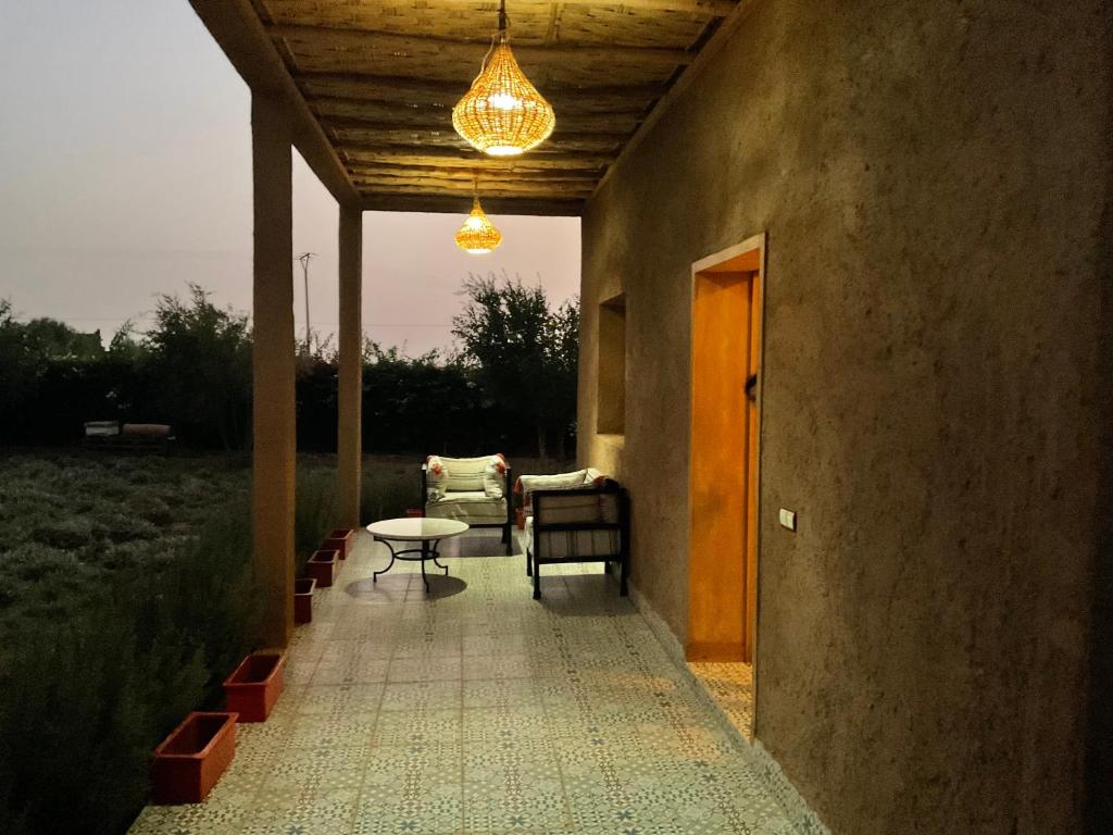 a patio with a table and chairs and a chandelier at Domaine VILLA in Tameslouht