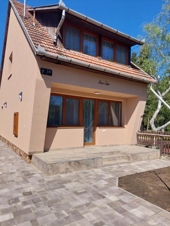 a house with a pathway in front of it at Árnyas Part Vendégház in Gyomaendrőd