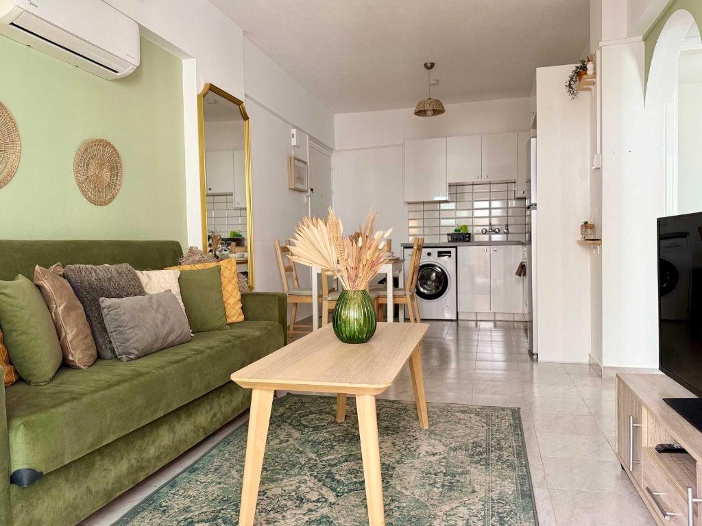 a living room with a green couch and a table at Coastal 2BR Apt in Mackenzie Steps from Beach by Cyprus Horizons in Scala