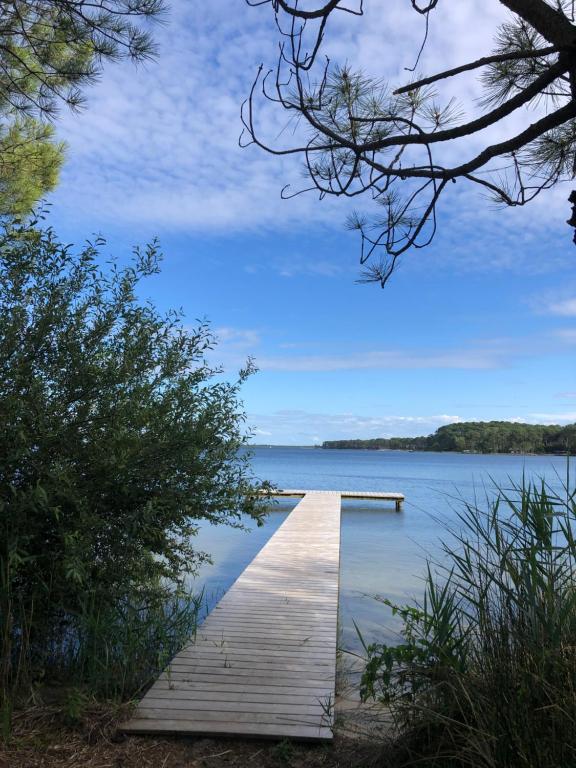 a dock on a lake with a blue sky at Maison Maubuisson proche du lac de Carcans in Carcans