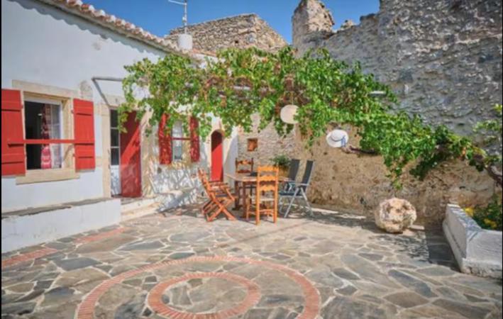 a patio with a table and chairs next to a building at Trifillianika Traditional House in Trifilliánika