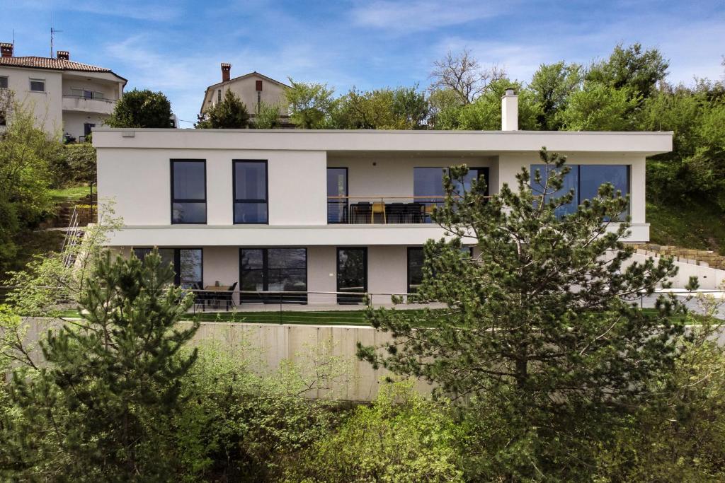 a house on a hill with trees at Apartment La Lita Panoramic Sea View Parking Self Checkin in Šmarje