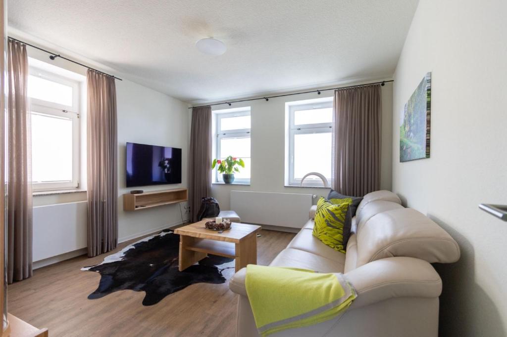 a living room with a couch and a table at Exklusives Appartement mit Flair in Oelsnitz