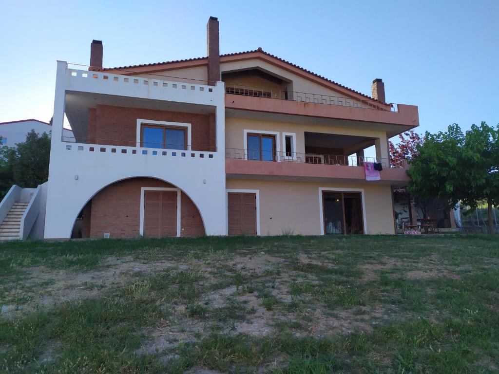 a large house on top of a grass field at Mulberry Tree in Agia Anna