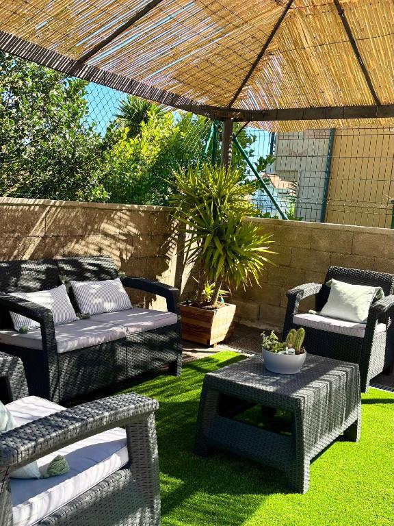 a patio with wicker chairs and a table in the grass at Casa vacacional Ajo in Ajo