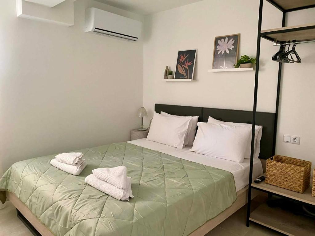 a bedroom with a bed with white towels on it at Nikol's central suite 2 in Nea Peramos