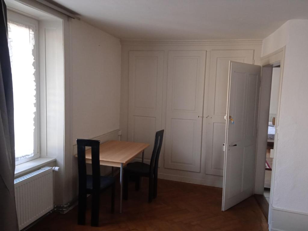 ein Esszimmer mit einem Tisch und zwei Stühlen in der Unterkunft Chambre D in Biel