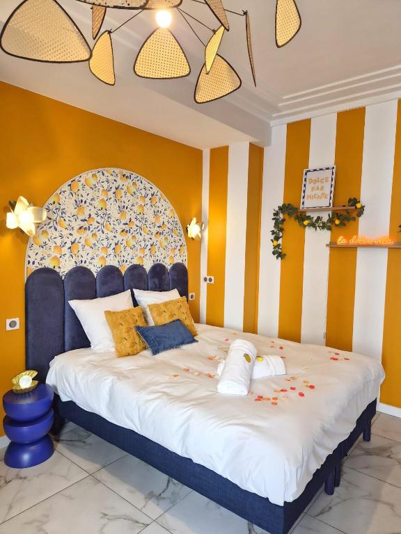 a bedroom with a large bed with yellow and white stripes at Ciao Bella Wellness Suite - Luxury Jacuzzi, Massage Table & AC in Central Nice in Nice