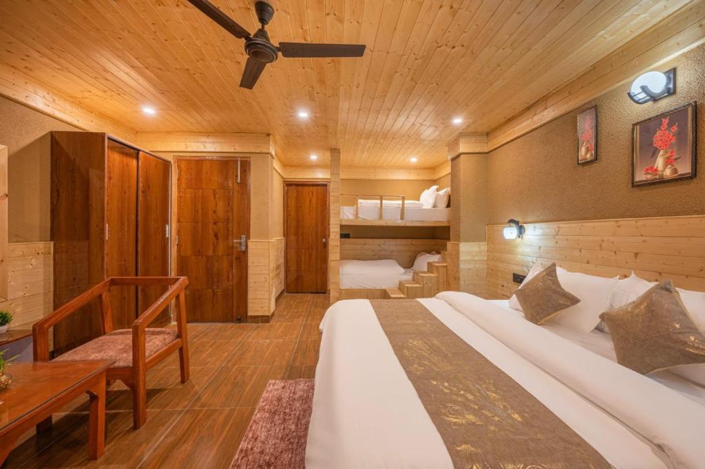 a bedroom with two beds and a ceiling fan at The Charvi Hotels I Vacations I Conference I MICE I Family Events I Open Air Terrace I Sky Bonfire I Charvi Retreat by Exotic Stays in Shimla