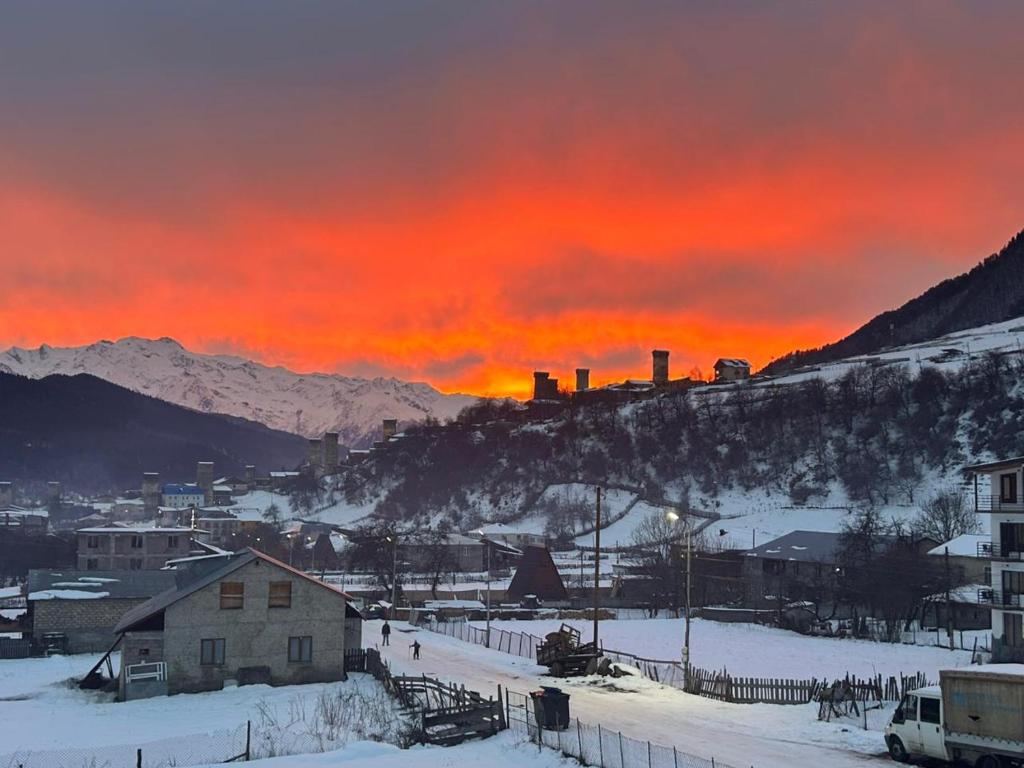 a sunset over a town in the snow at Mariana's Guest House in Mestia