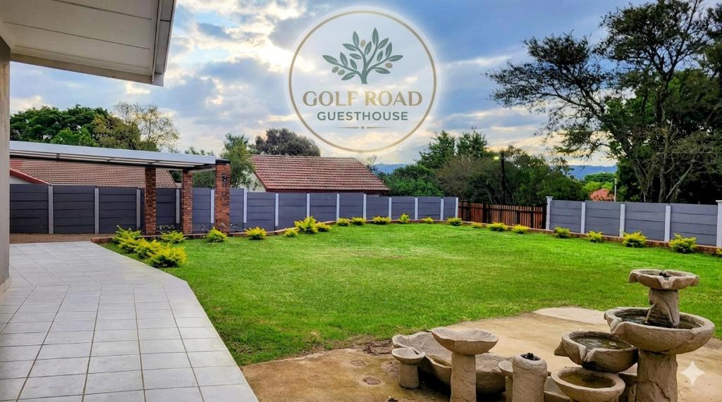 a garden with a cot road customer sign in the background at Golf Road Guesthouse in Pietermaritzburg