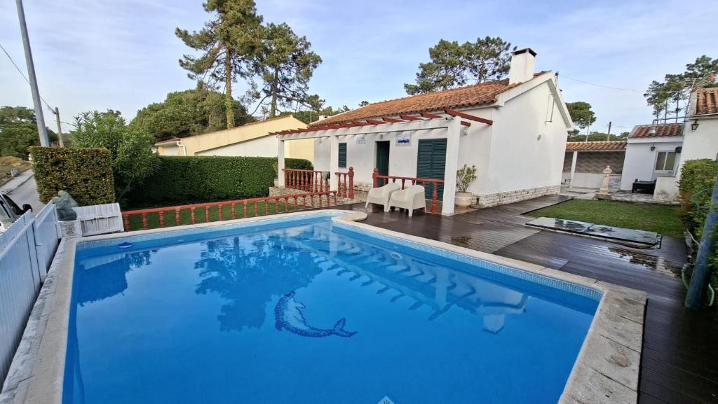 a swimming pool in front of a house at Vivenda Prazeres in Sesimbra