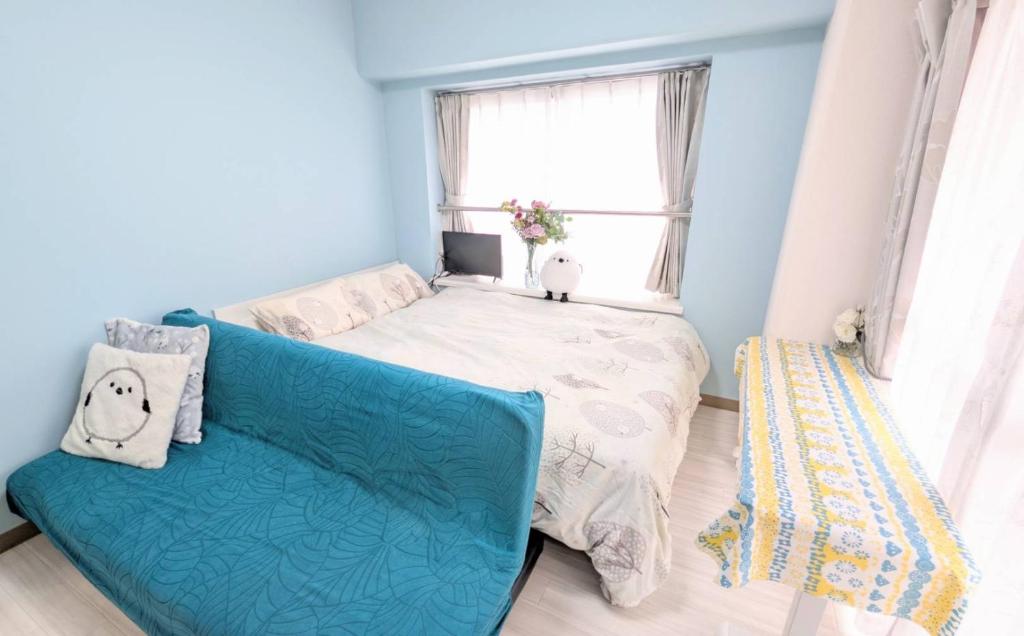 a small room with a couch and a window at MIYAVI#407 3min walk Narimasu Station, 3 people, double bed & sofa, Tokyo's largest Don Quijote in Tokyo