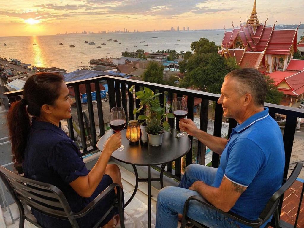 a man and woman sitting at a table with glasses of wine at Beach Front Condo Centerviews Bangsaray Floor 7 in Bang Sare