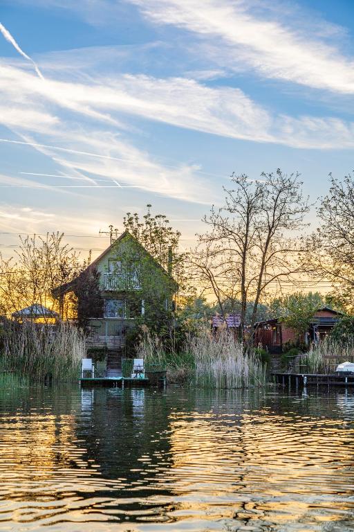 a house sitting on the side of a body of water at Dunai Menedék in Ráckeve