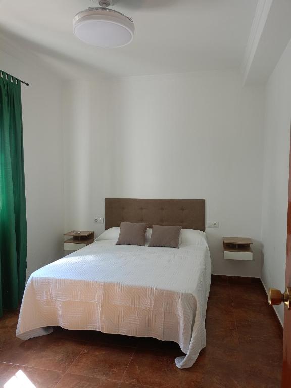 a bedroom with a large white bed in a room at Casa Feria in Algodonales