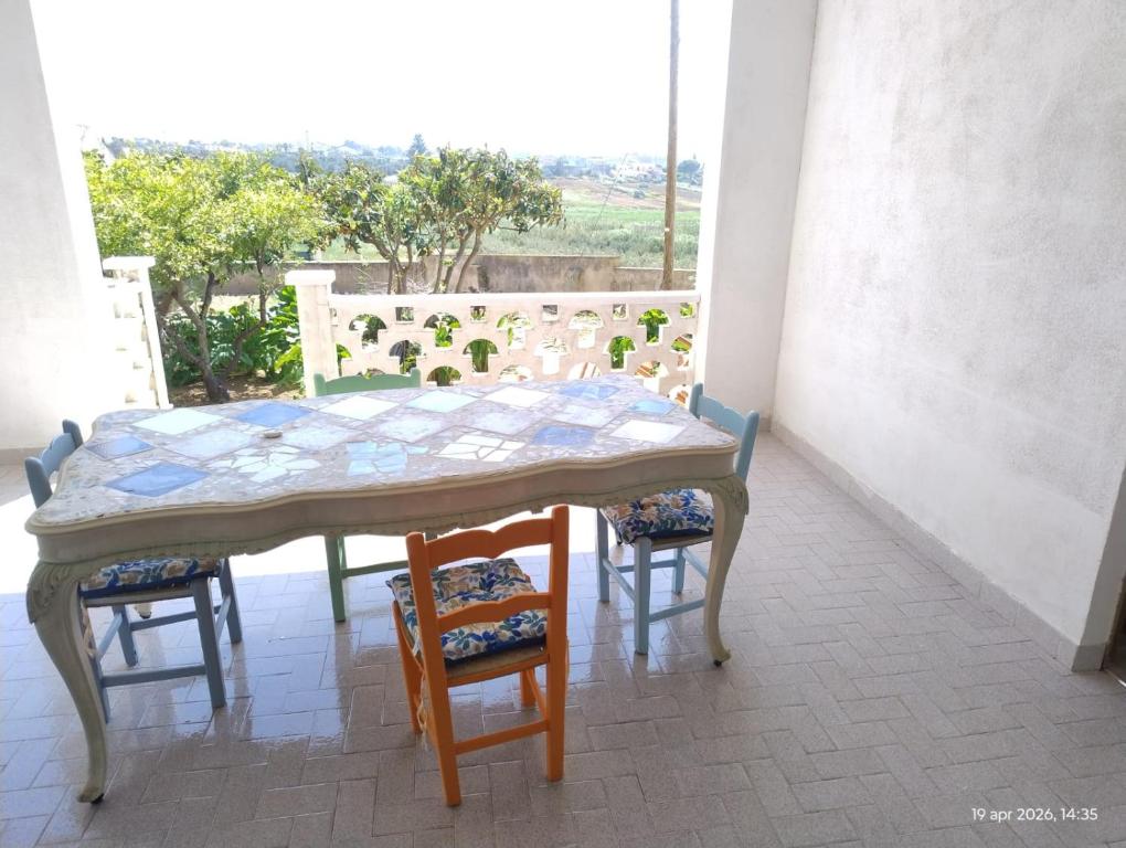 a table and chairs in a room with a window at Adamo Flat in Bisciano