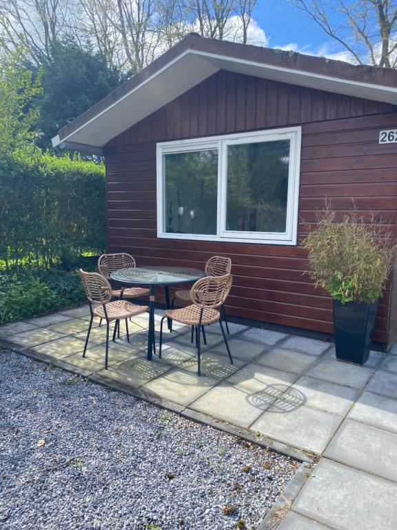 a patio with a table and chairs in front of a house at Tiny house Schoorl Bergen NH in Warmenhuizen