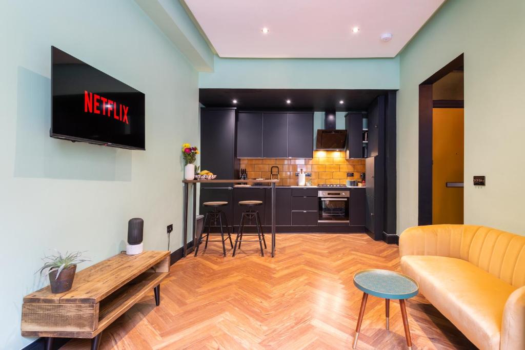 a living room with a couch and a kitchen at Edinburgh Centre - Holyrood Apartment in Edinburgh