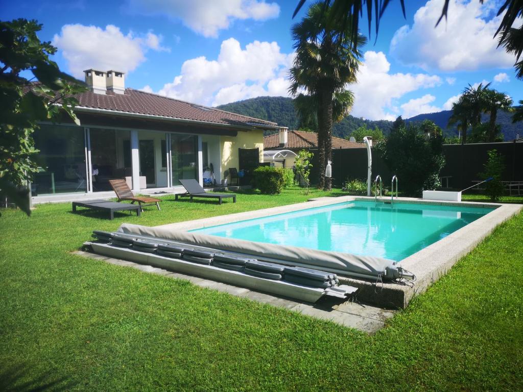a swimming pool in the yard of a house at Pratofiorito Apartment in Caslano
