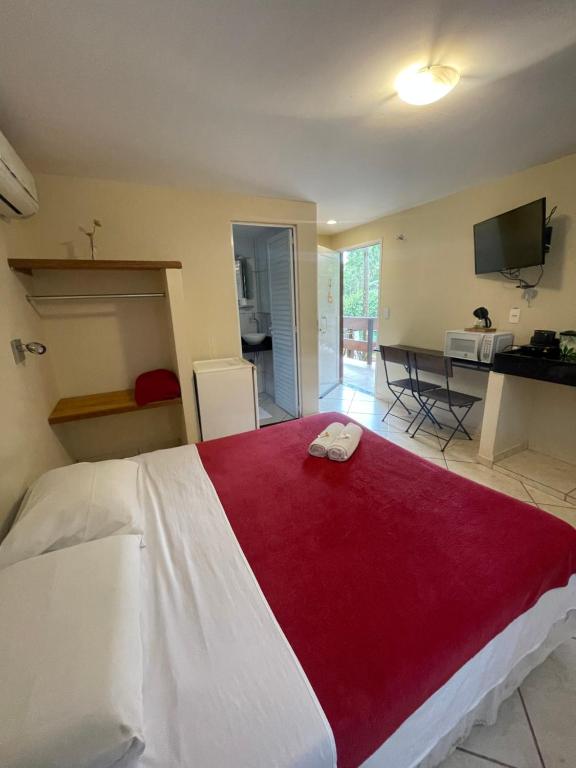 a bedroom with a large bed with a red blanket at Flat Salto Dagua Penedo in Penedo
