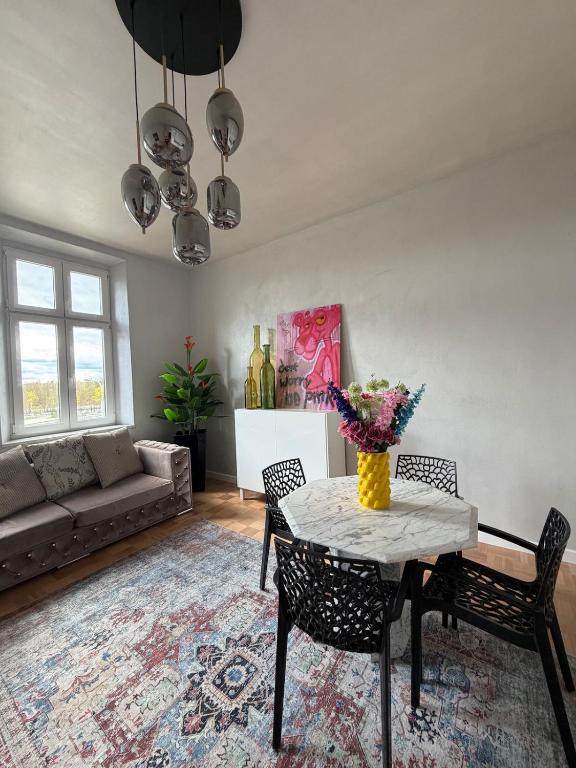 ein Wohnzimmer mit Tisch, Stühlen und Sofa in der Unterkunft Dream flat in Pilsen