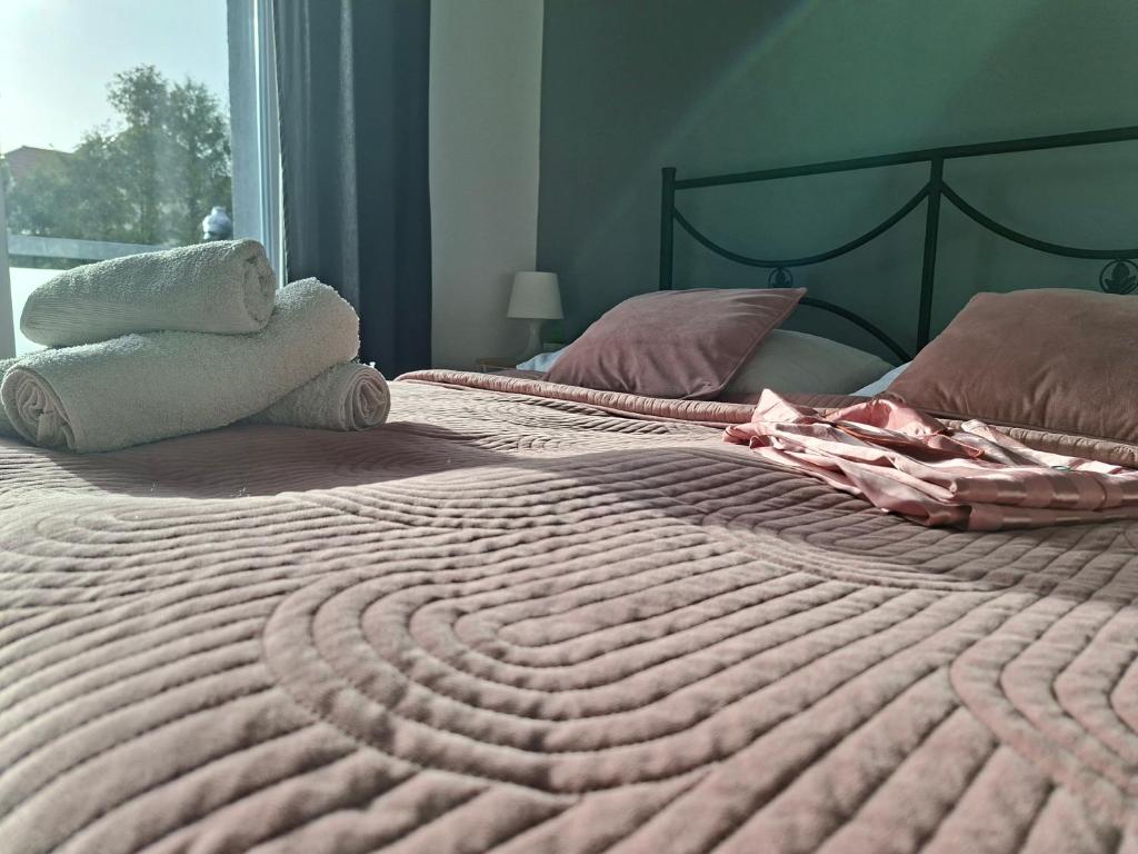 a bed with a pink comforter and two stuffed animals on it at Azalia 32 Mielno l in Mielno