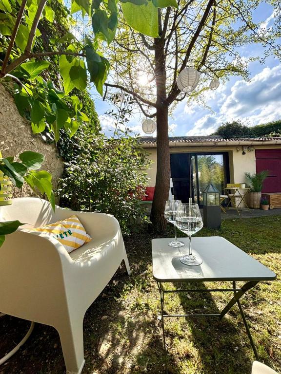 a white chair and a table with a wine glass at Le joli jardin face à l'Abbaye in Pont-à-Mousson