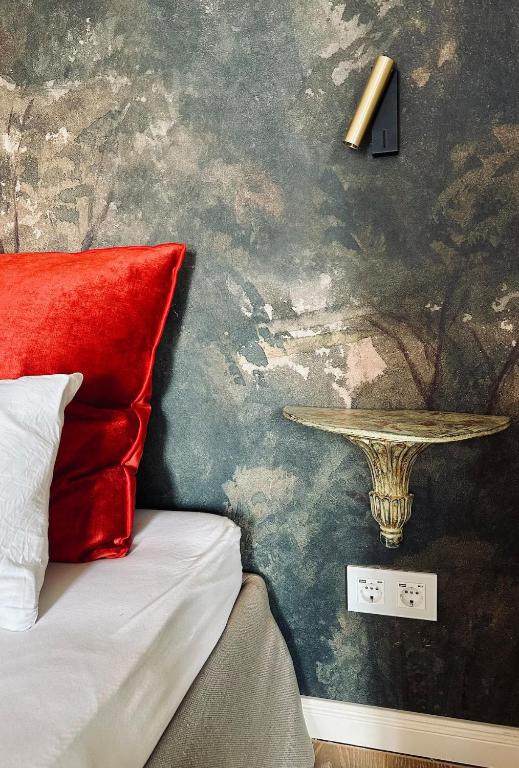 a bedroom with a bed with a red pillow and a table at Villa Conte Private Urban Hideaway in Wels