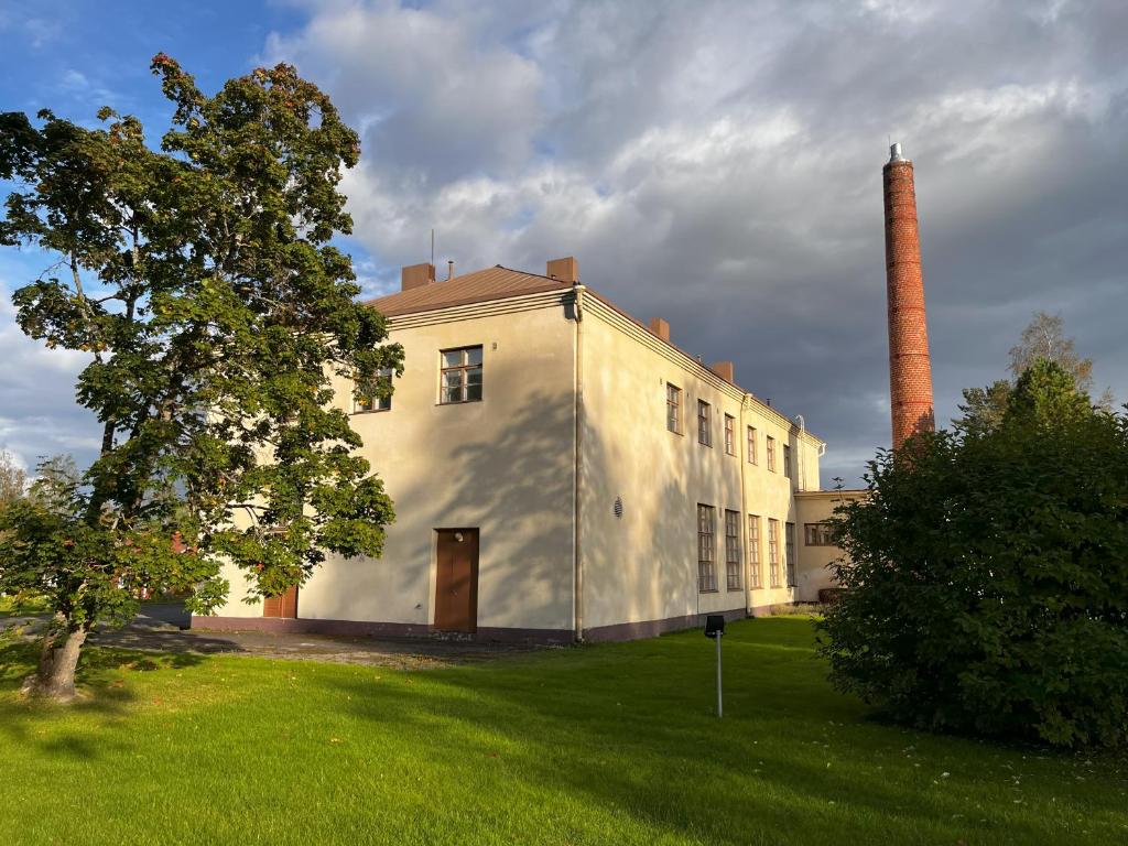 a large white building with a smoke stack at Villa Karijoki in Karijoki