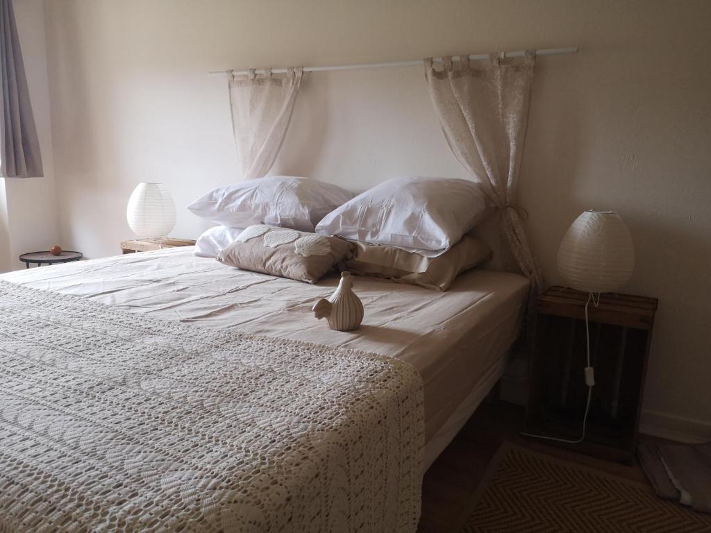 a bedroom with a bed with white sheets and pillows at Chez ma poule in Moissac