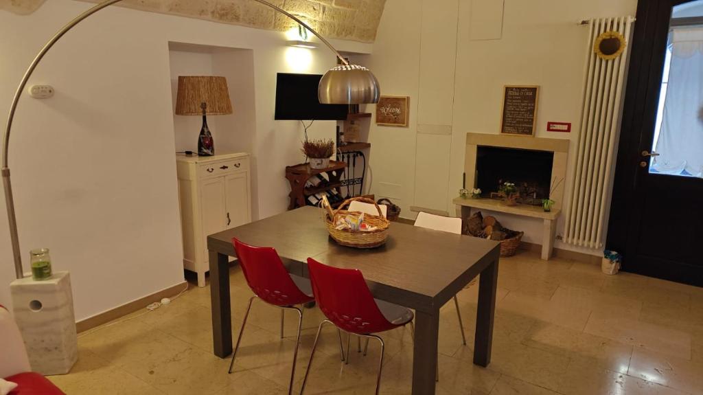 a living room with a table and two red chairs at Alle volte… in Bisceglie