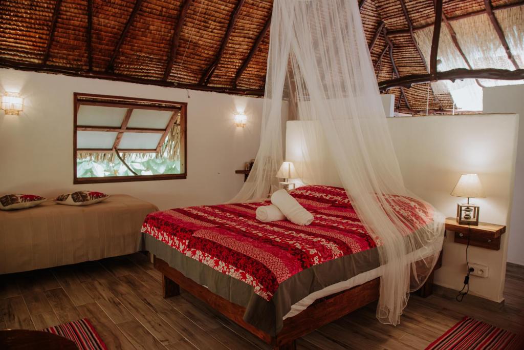 a bedroom with a bed with a mosquito net at Fare Hau Lodge in Tahaa