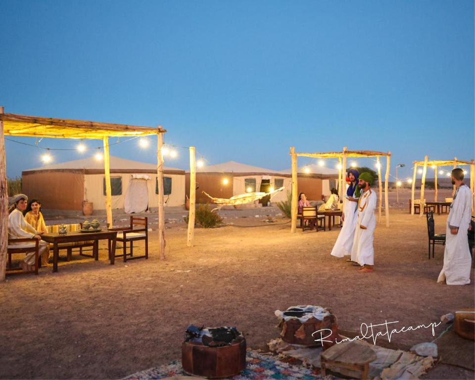 a bride and groom are standing under a tent at Rimal tata camp in Migourdâne