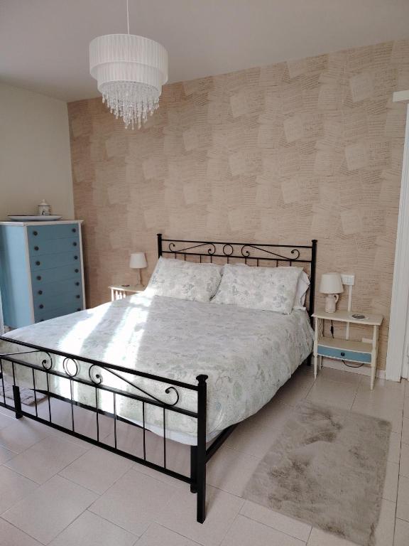 a bedroom with a large bed and a chandelier at Via Funicolare in Brunate