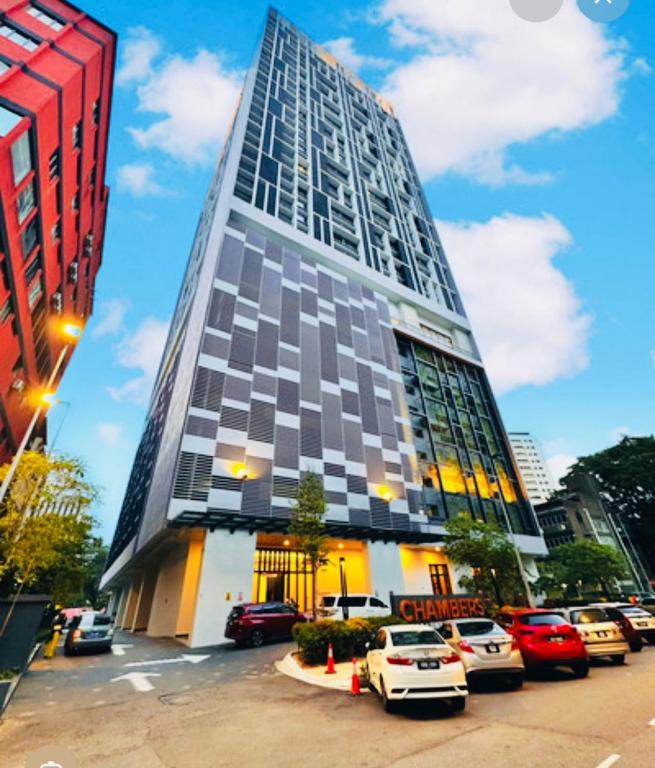 a tall building with cars parked in front of it at Chamber Haven KL in Kuala Lumpur