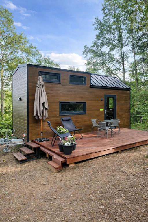 a tiny house on a wooden deck with a patio at La Tiny House de Nanou in Rochefort