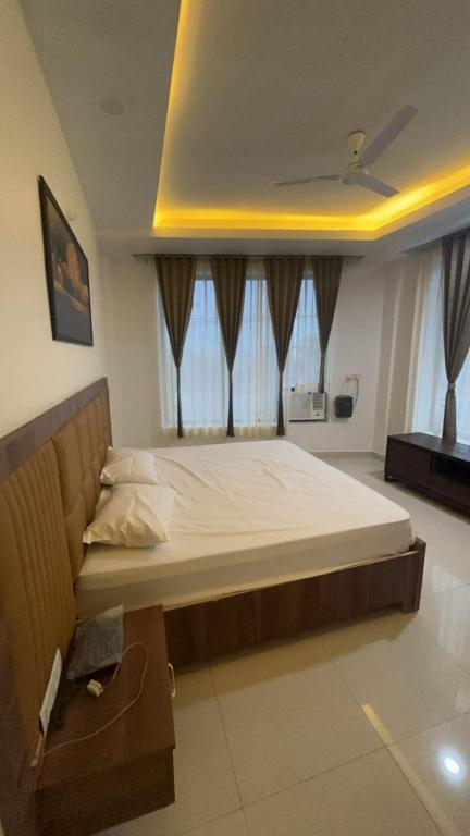a large bed in a room with windows at Hotel Elite in Palwal