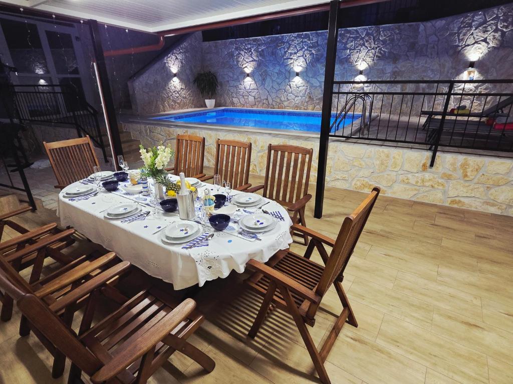 a dining table and chairs in a restaurant with a pool at Adria Stone House in Grižane