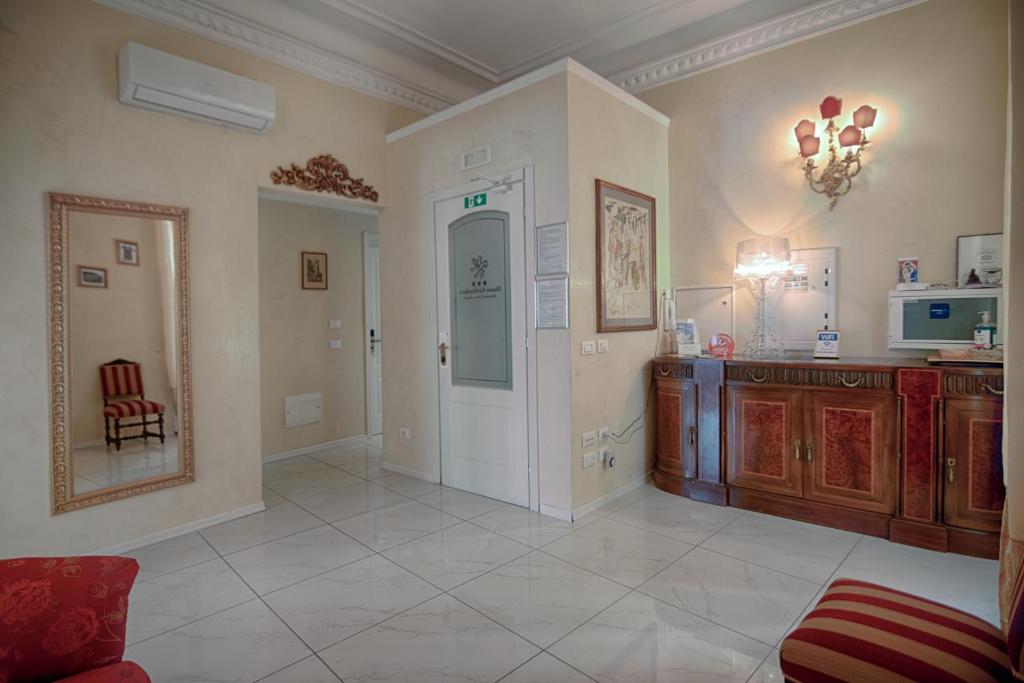 a large living room with a table and a mirror at Home Grifondoro Affittacamere in Genoa