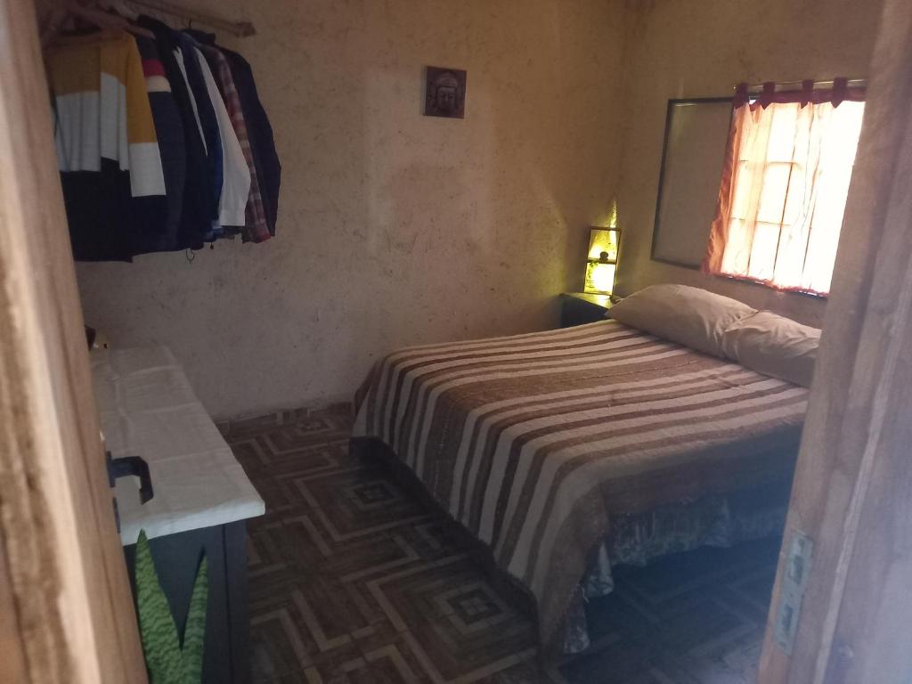 a small bedroom with a bed and a window at El PRADO in Alta Gracia