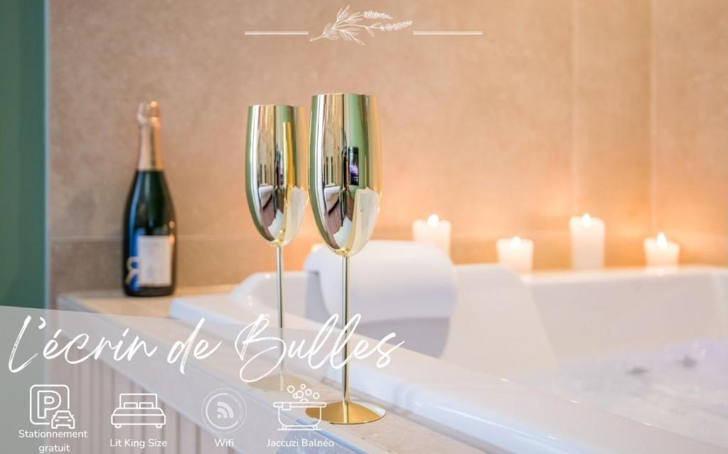 a couple of wine glasses sitting on top of a bath tub at Ecrin de bulles - Jacuzzi & clim in Les Cabannes