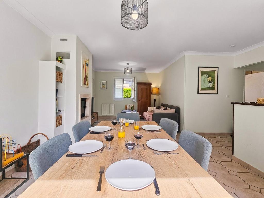a dining room with a large wooden table and chairs at Villa La Dorada, Normandy in Ver-sur-Mer