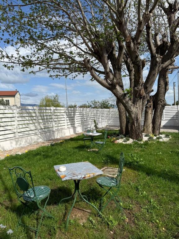 a table and two chairs in a yard with a tree at B&B Aura in Pontecagnano