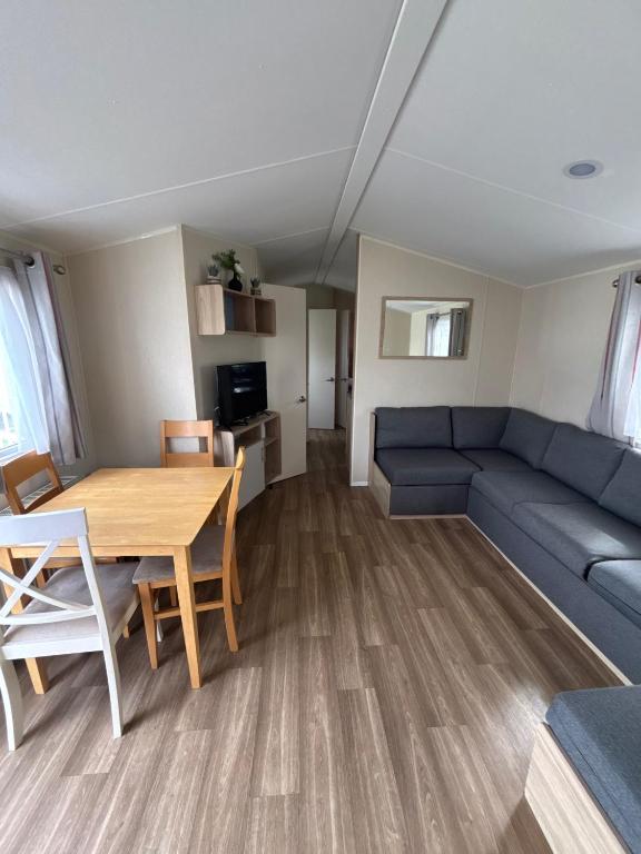 a living room with a blue couch and a table at Seaside Lodge Haven in St Osyth in Jaywick Sands