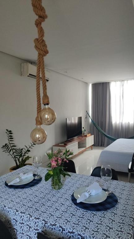 a room with a table with plates and wine glasses at Itapuã Beach - Espaço Aconchegante e Tranquilo pra você e sua família! in Salvador